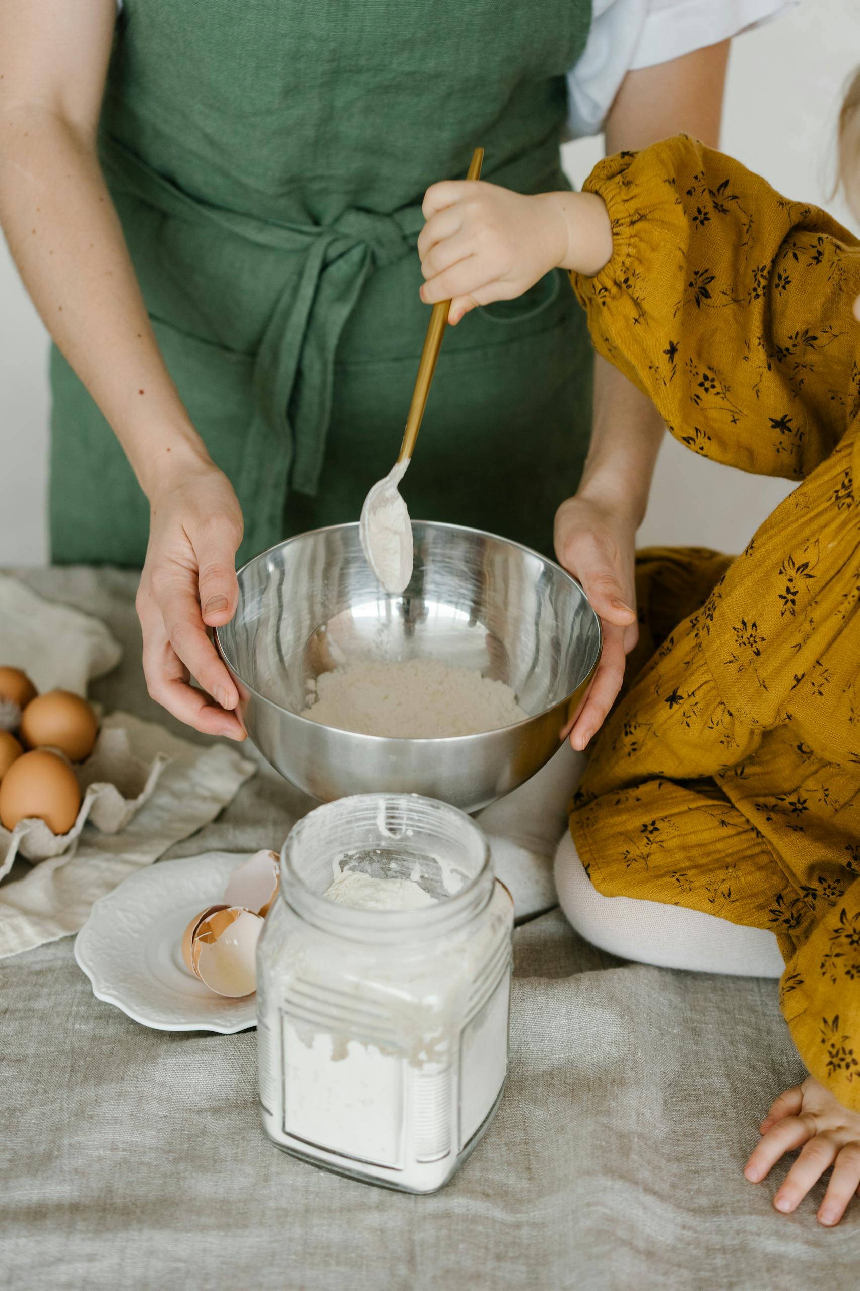 Mother and child mixing dough in a bowl, symbolizing family togetherness and home baking.