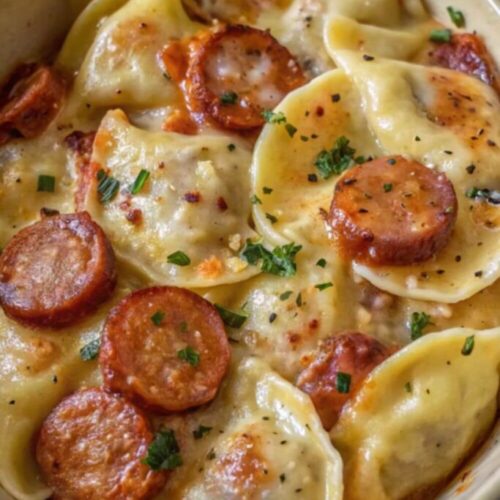 Pierogi casserole with sliced kielbasa in a dish.